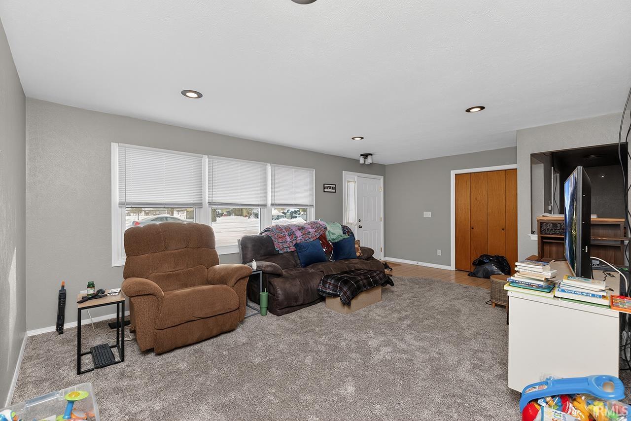 Carpeted living room featuring baseboards and recessed lighting