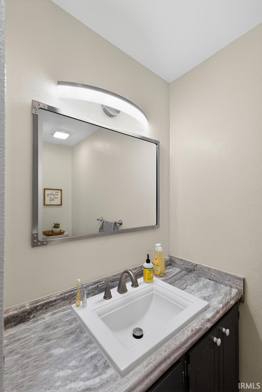 Bathroom featuring vanity and a textured wall
