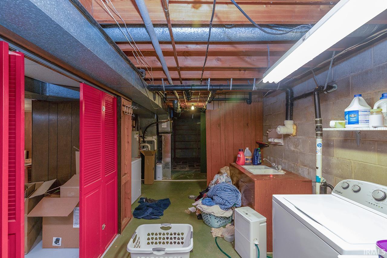 Unfinished below grade area with heating unit and a sink