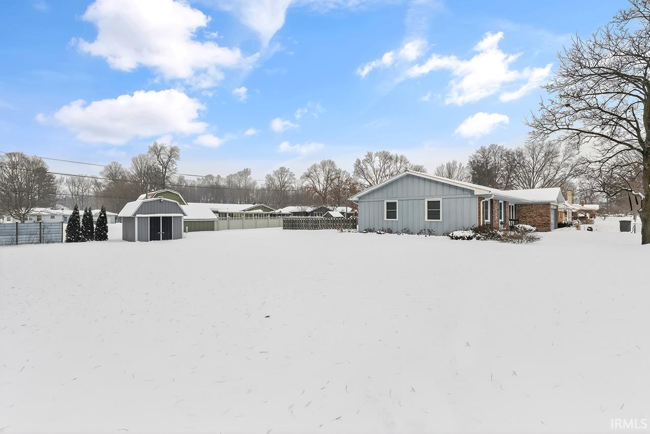 Yard covered in snow with an outdoor structure