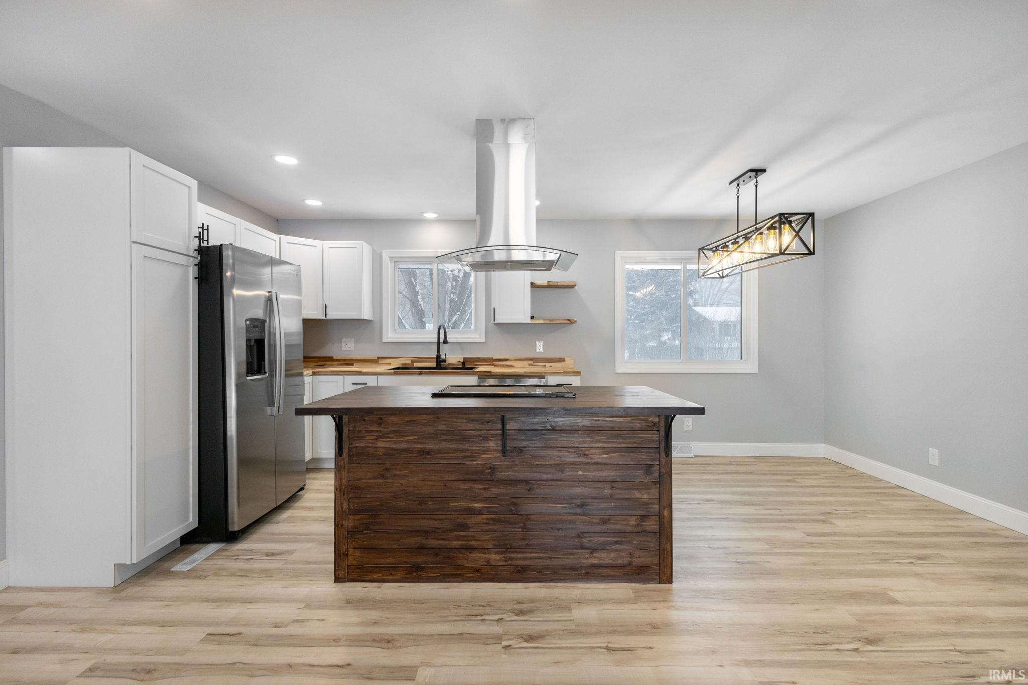 Kitchen with white cabinets, pendant lighting, open shelves, light wood-style floors, and recessed lighting