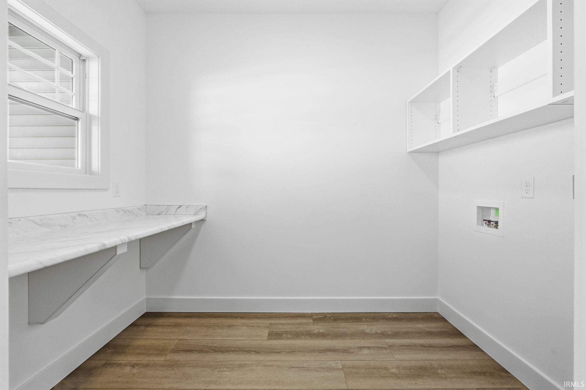 Laundry room with light wood-style floors and hookup for a washing machine