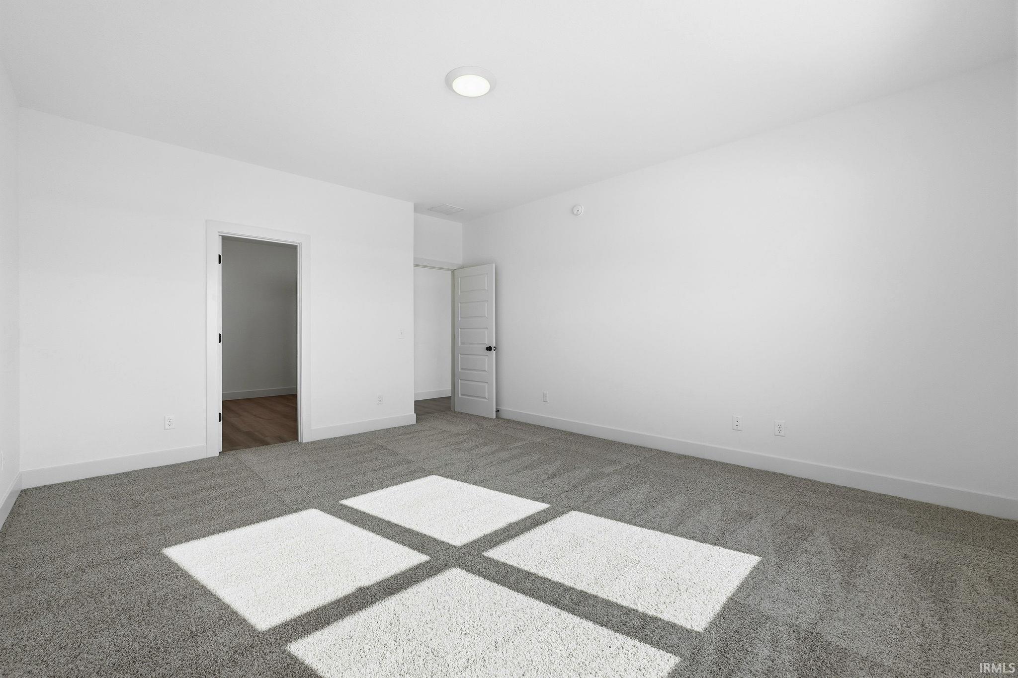 Unfurnished bedroom featuring light colored carpet