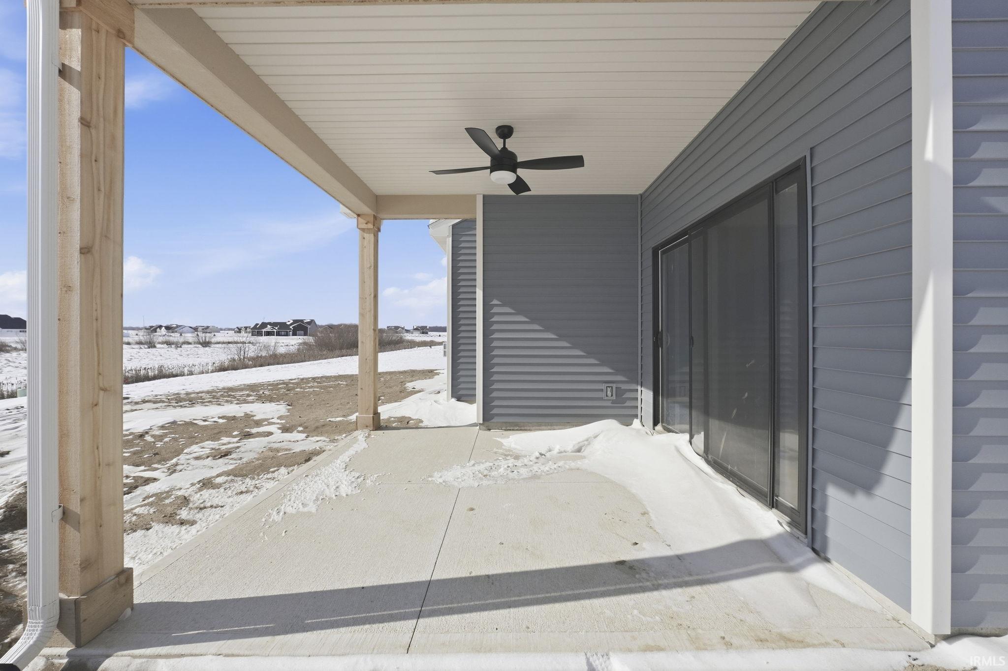 Snow covered patio with a ceiling fan and a patio area