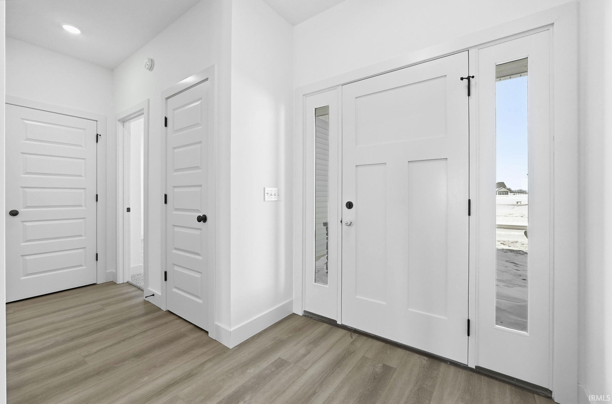 Foyer featuring light wood finished floors and recessed lighting
