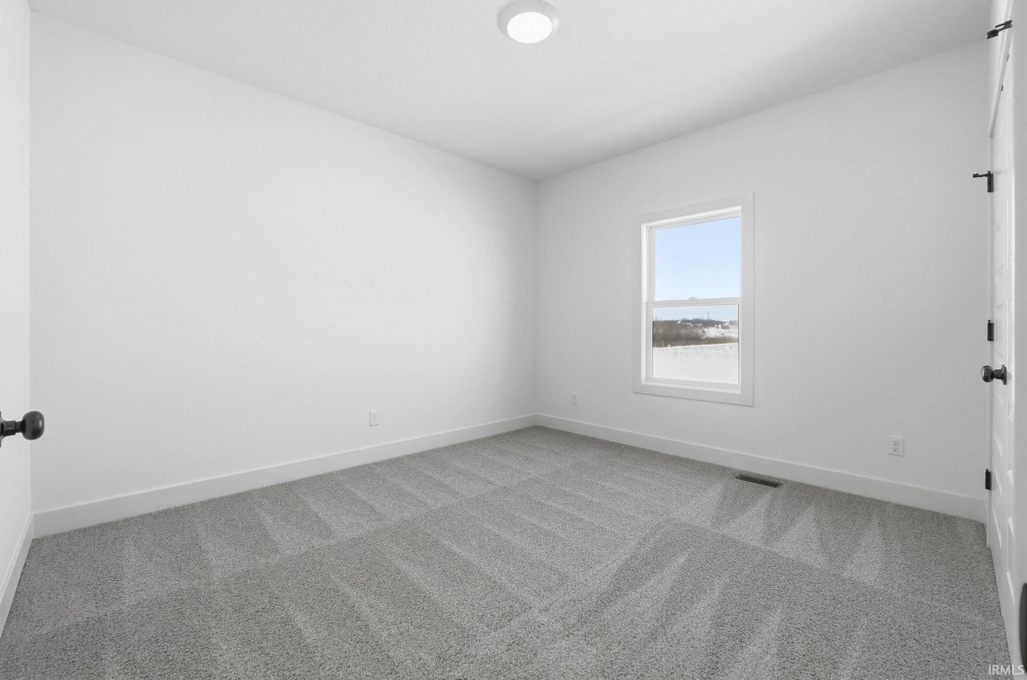 Empty room with carpet flooring and baseboards
