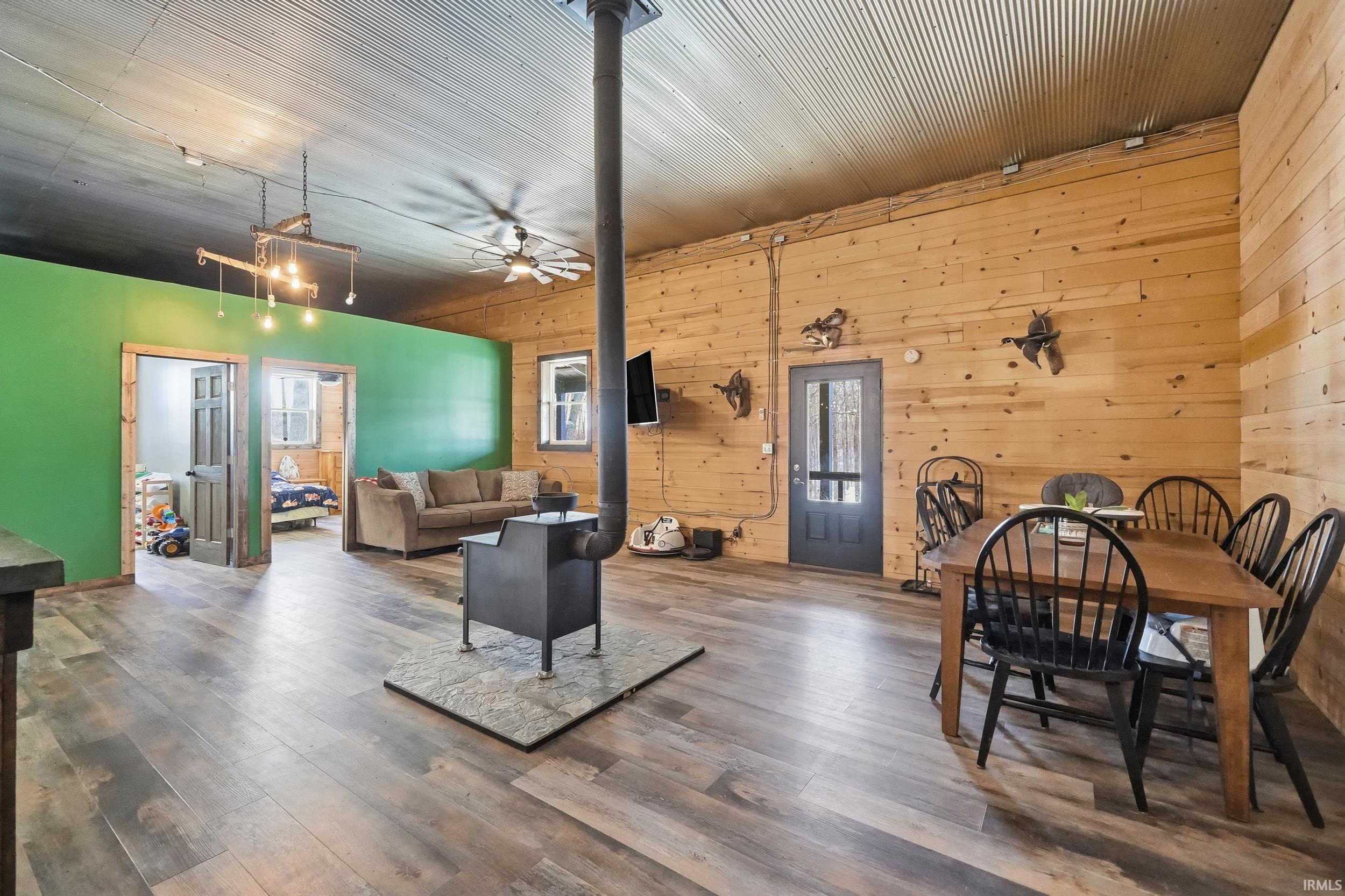 Dining room featuring wooden walls, hardwood / wood-style floors, and ceiling fan