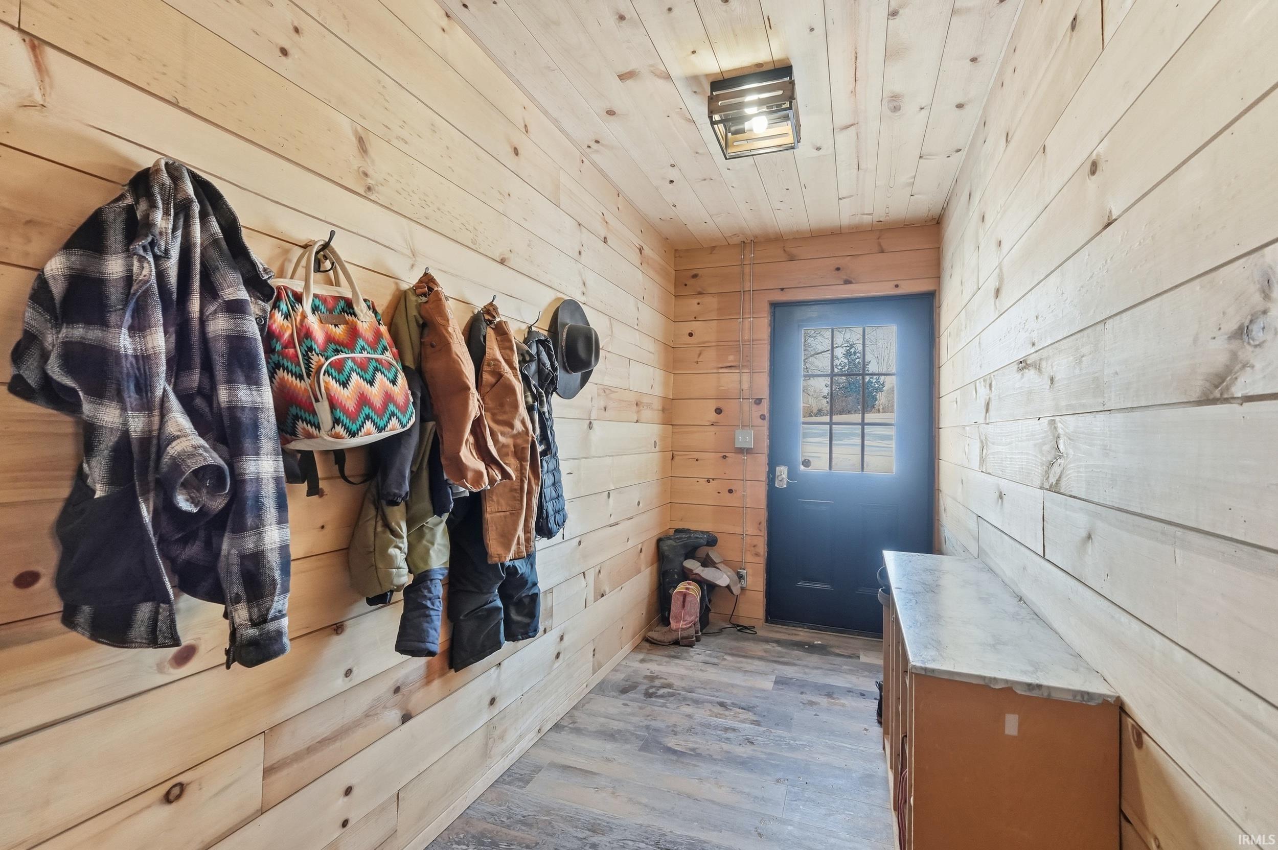 Mudroom featuring wood walls, wood finished floors, and wood ceiling
