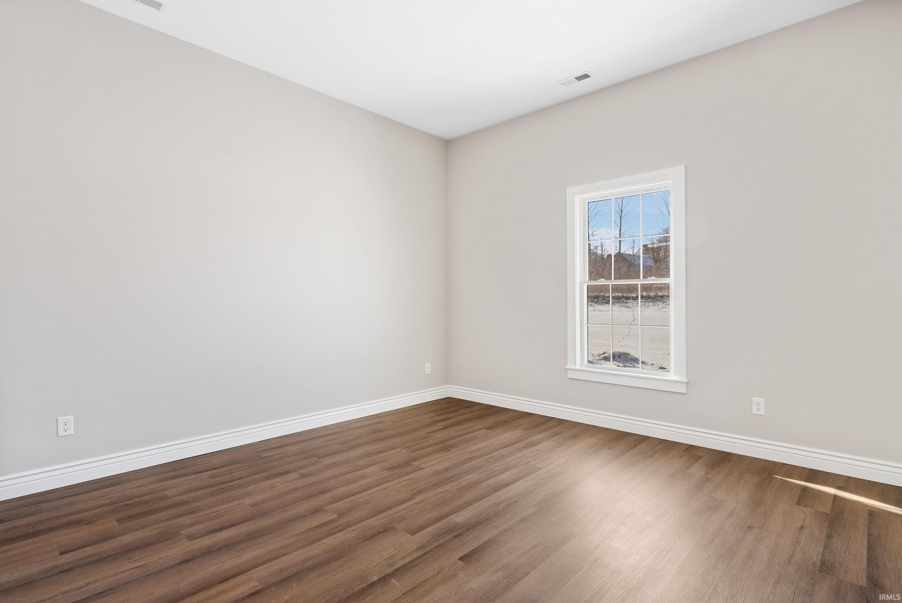 Empty room featuring wood finished floors and baseboards