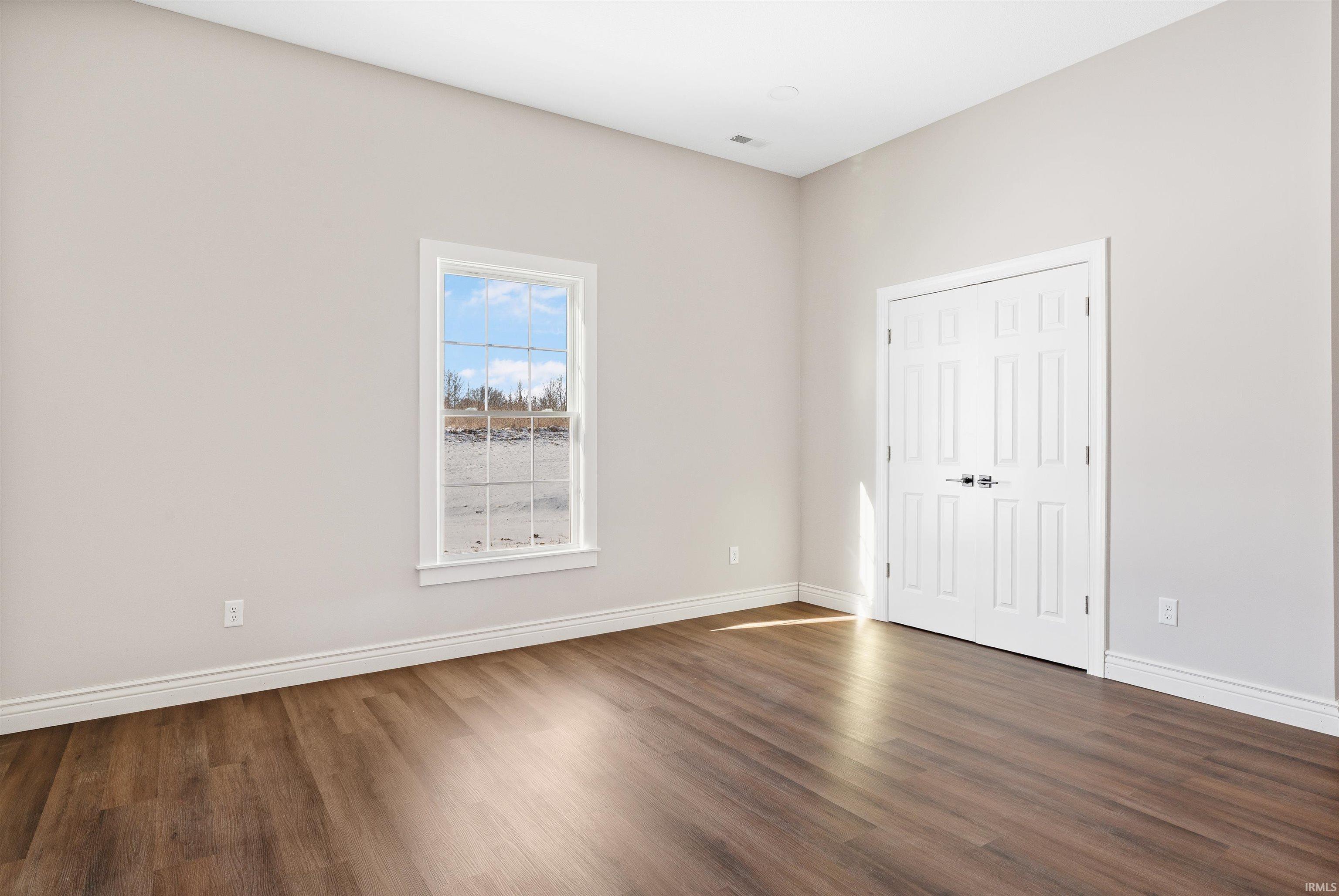 Unfurnished bedroom with wood finished floors and a closet