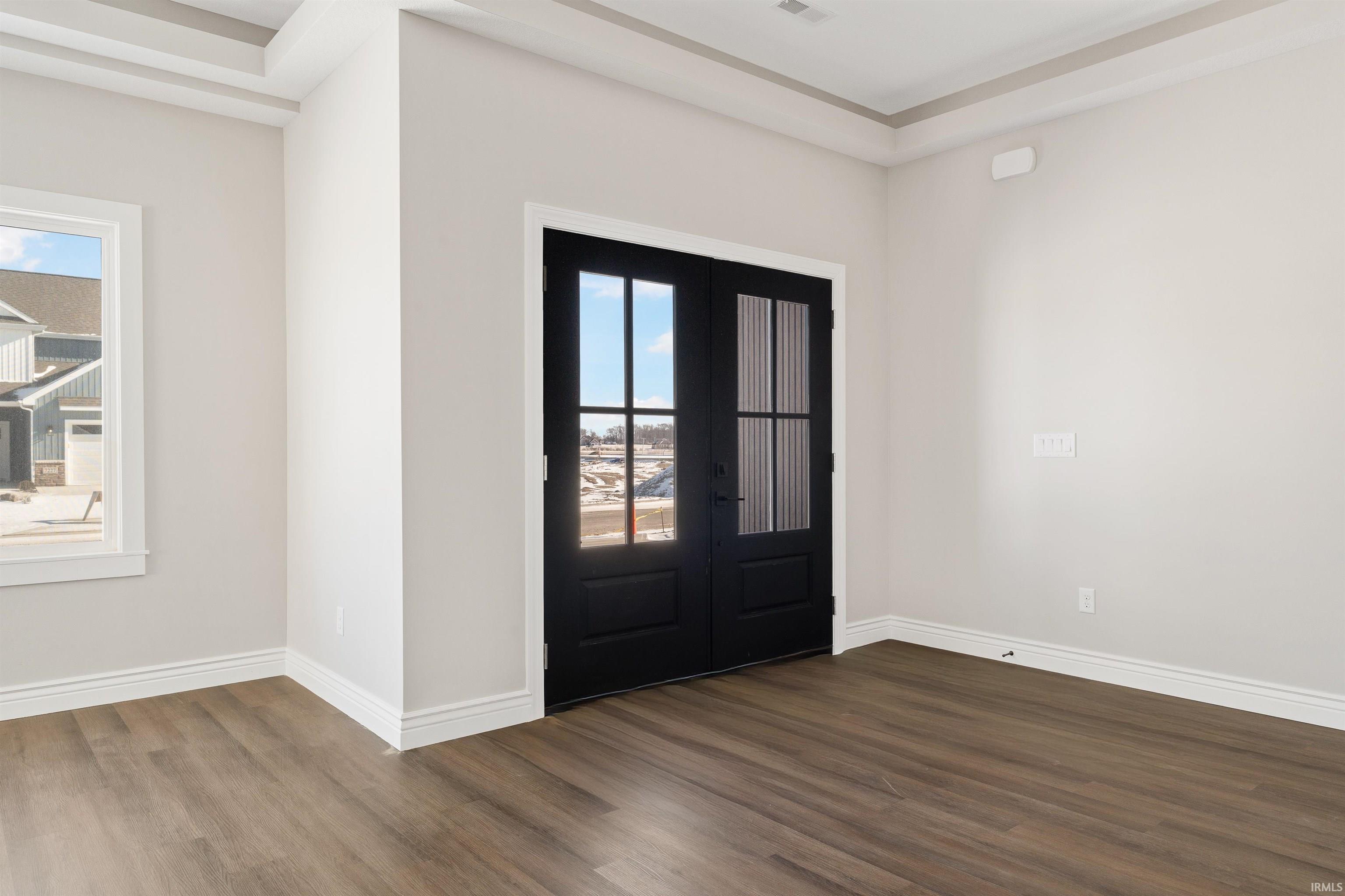 Entrance foyer featuring dark wood-type flooring, healthy amount of natural light, and french doors