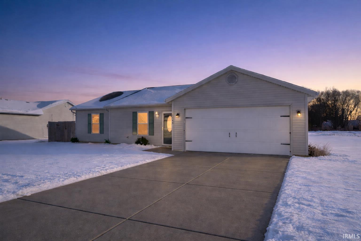 Single story home featuring an attached garage and concrete driveway