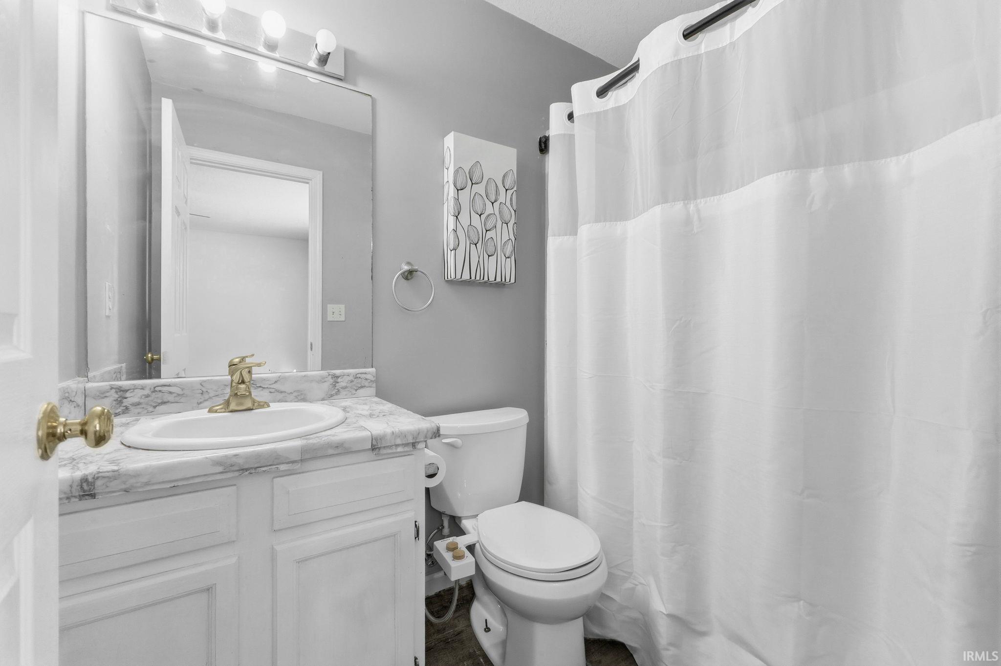Full bath featuring curtained shower and vanity