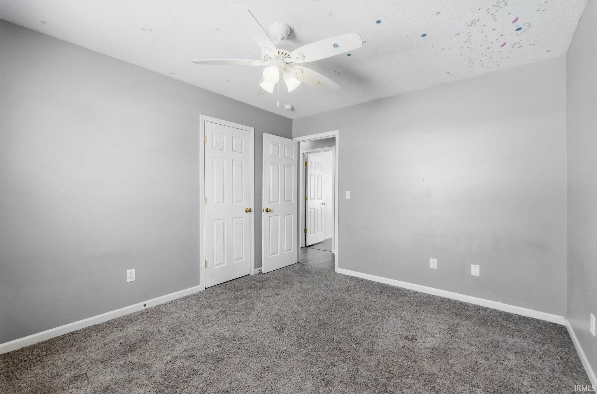 Unfurnished bedroom featuring carpet flooring and a ceiling fan