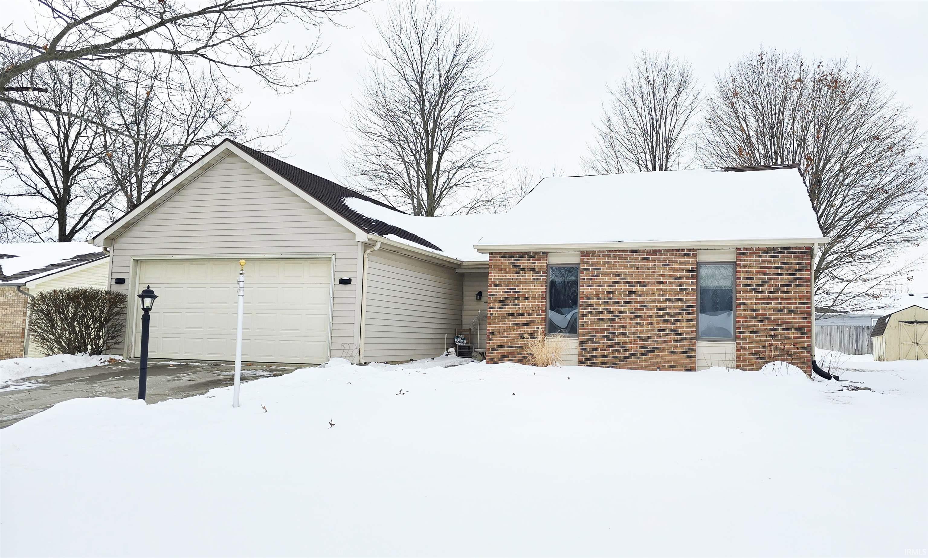 Ranch-style home with brick siding and a garage
