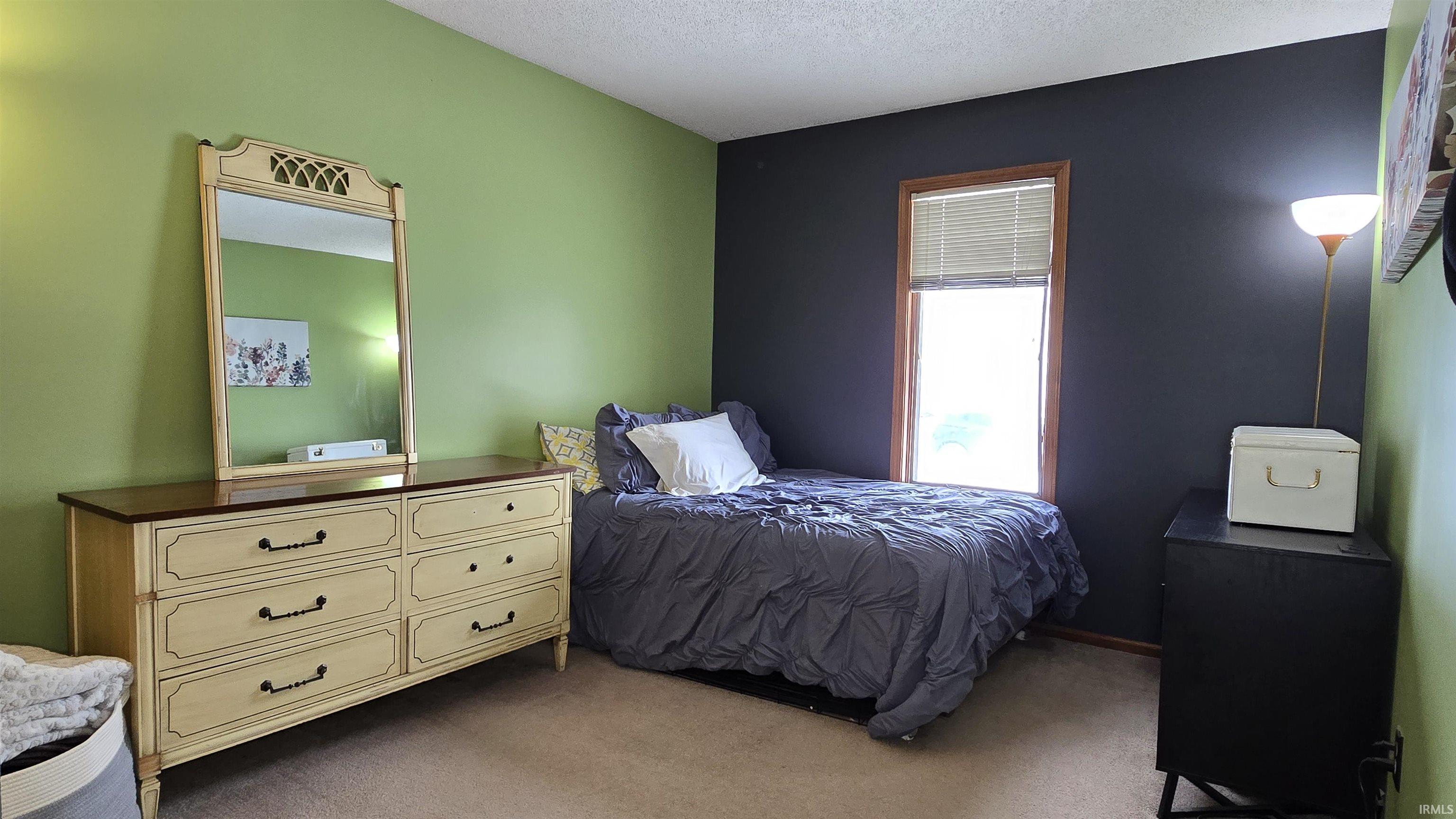 Carpeted bedroom featuring a textured ceiling