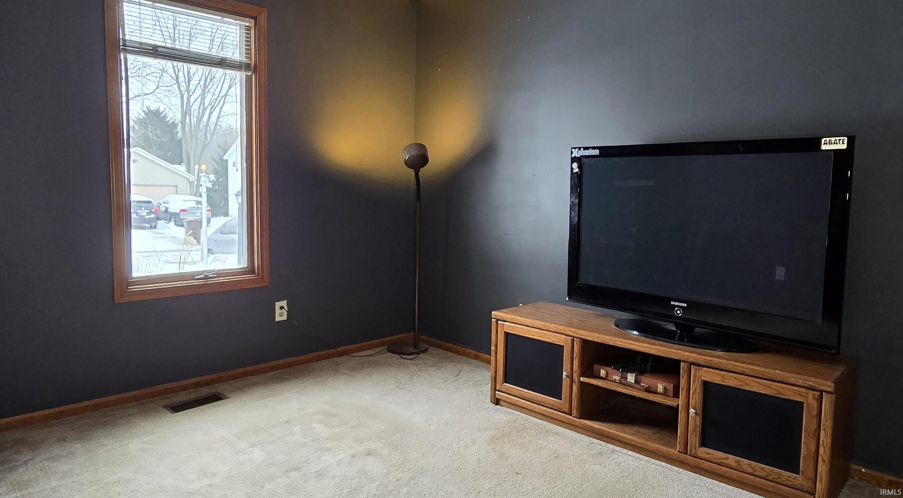 Unfurnished living room with carpet and baseboards