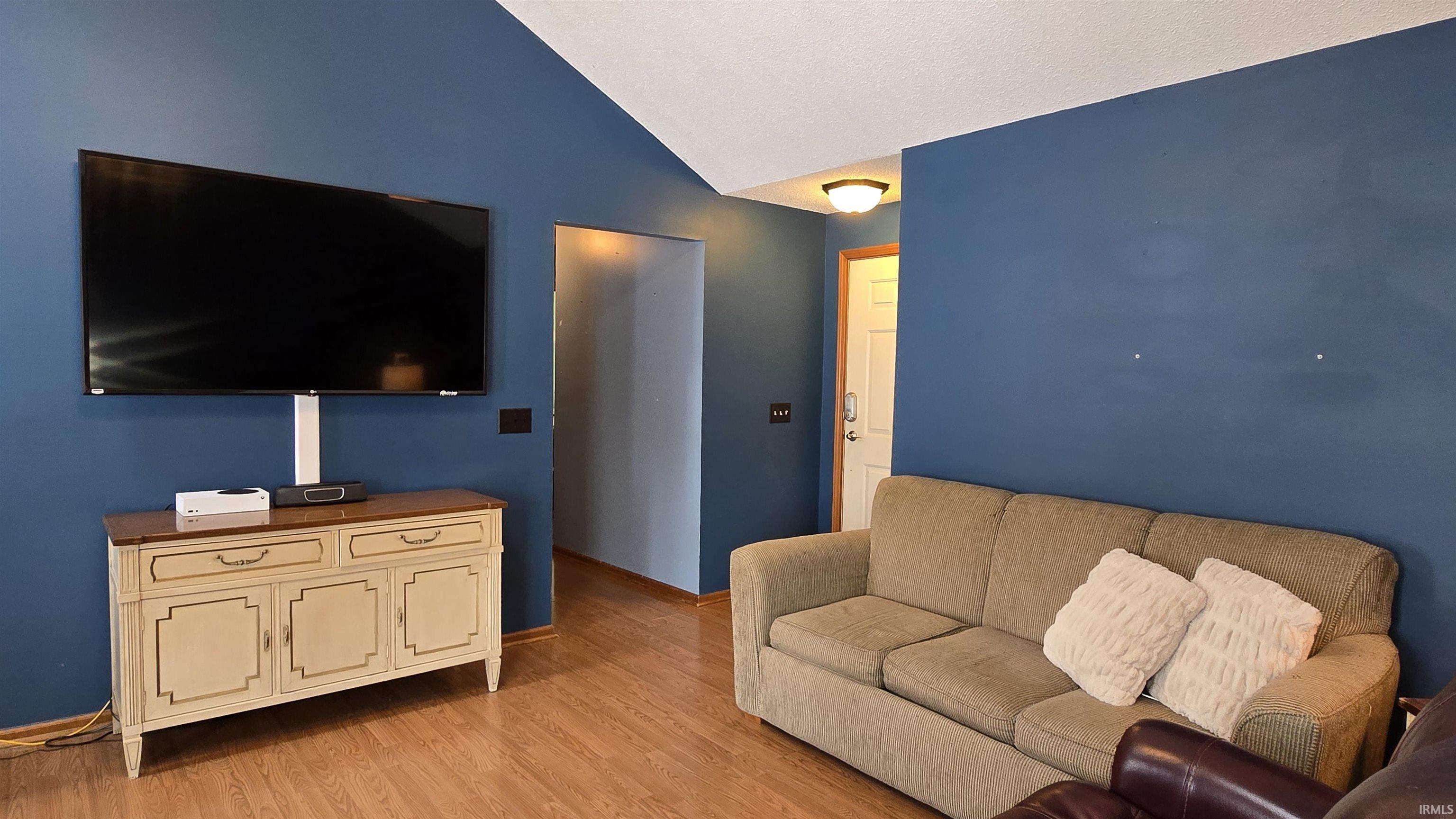 Living area with lofted ceiling and light wood finished floors