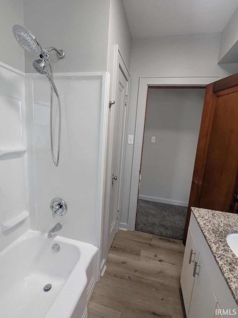 Full bathroom featuring vanity, shower / tub combination, and light wood-type flooring
