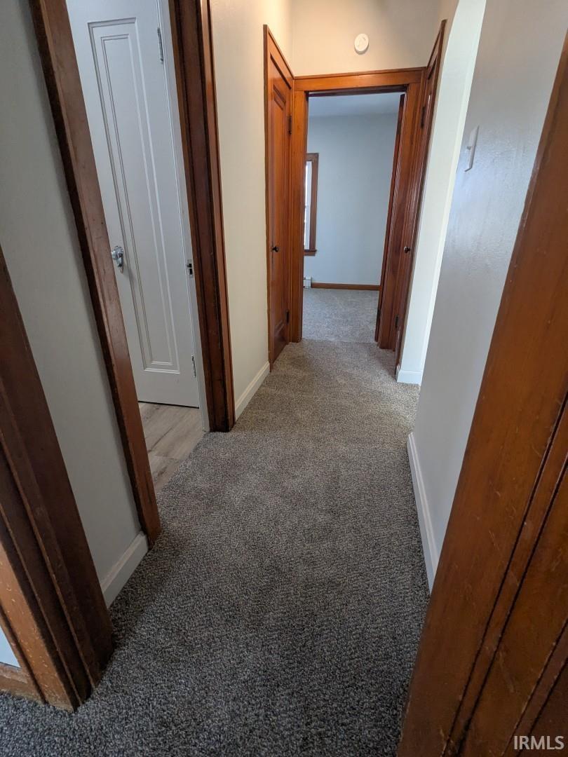 Corridor with light carpet and baseboards