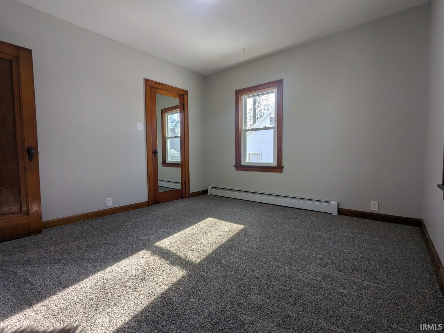 Unfurnished room with a baseboard radiator and carpet flooring