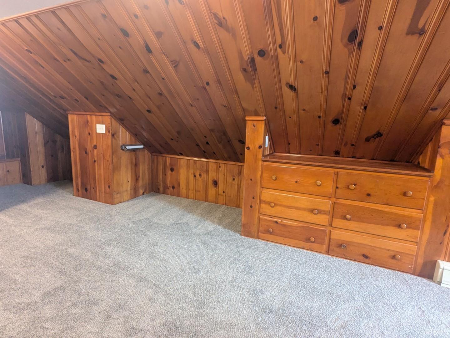 Additional living space with carpet floors, wooden walls, vaulted ceiling, and wooden ceiling