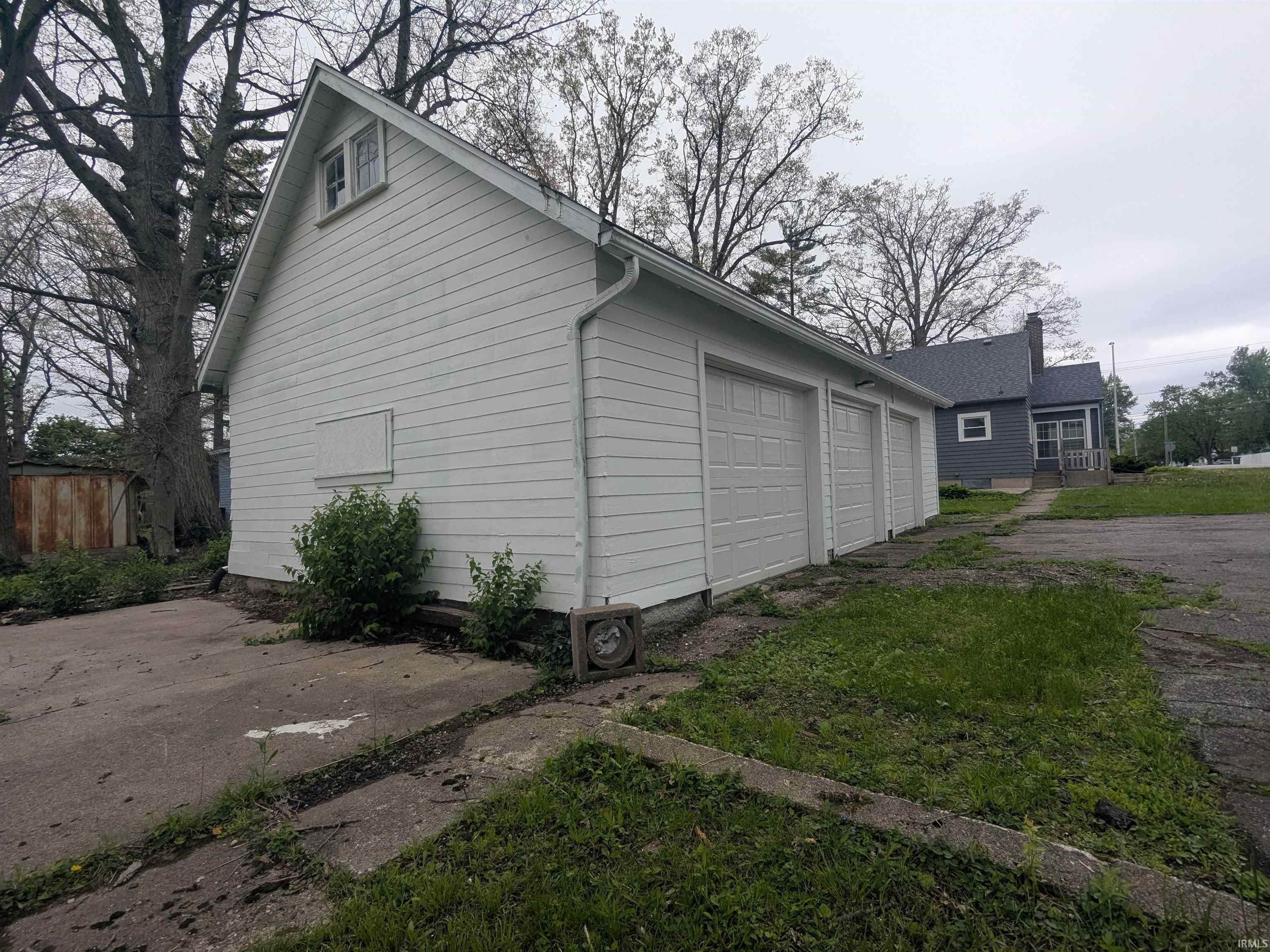 Detached two-car garage with white siding and individual garage doors
