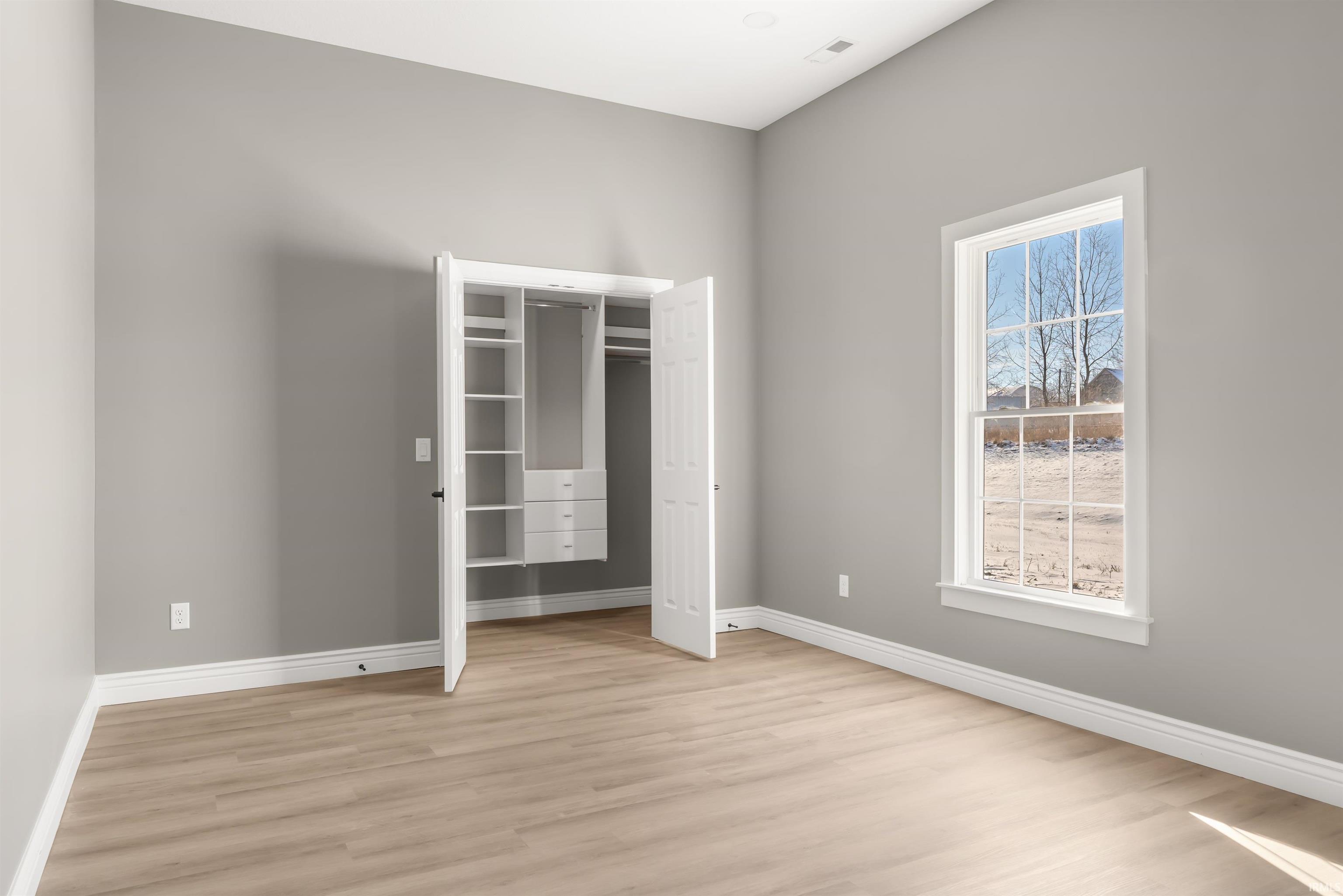 Unfurnished bedroom with light wood-style floors and a closet