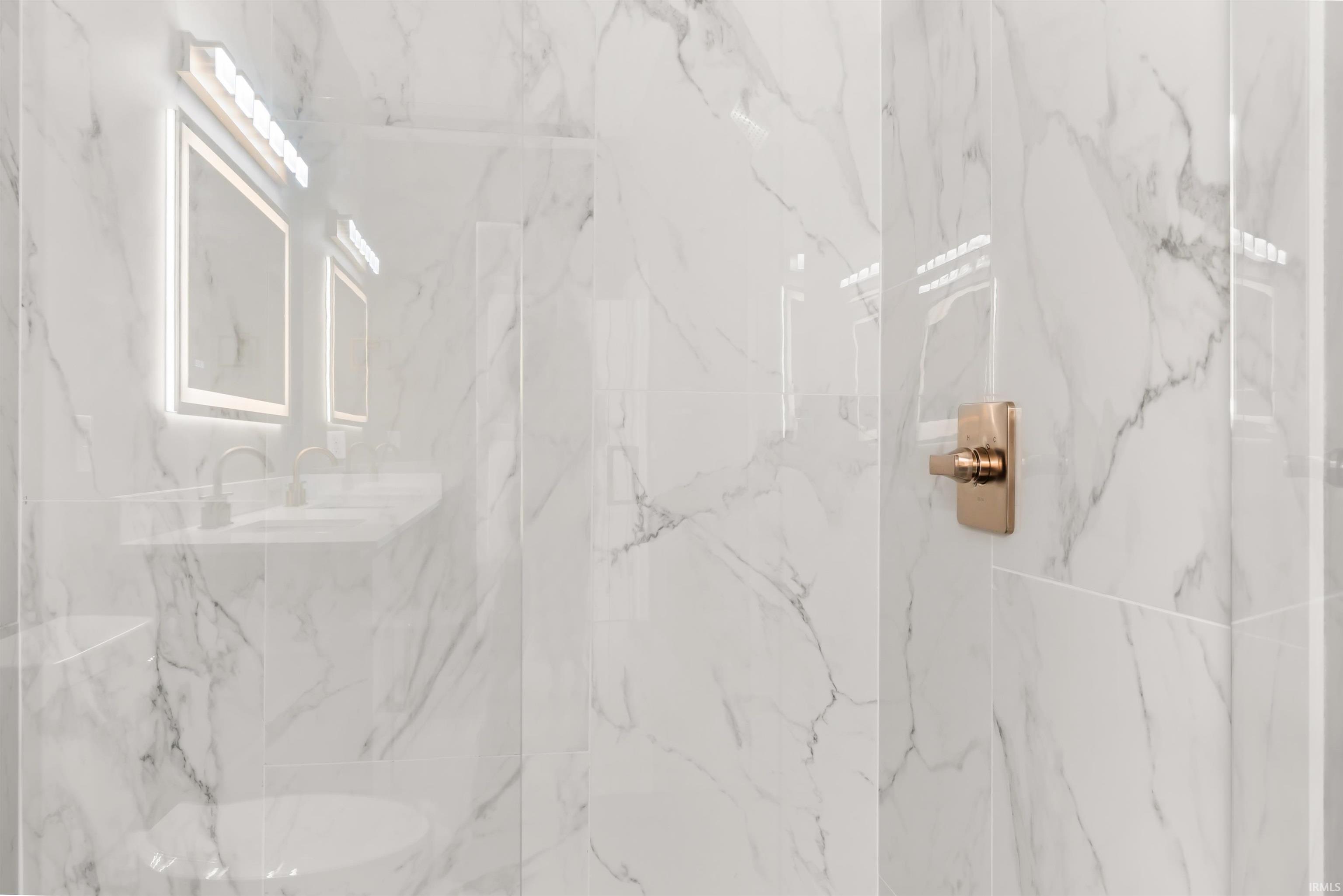 Full bathroom with a marble finish shower and vanity