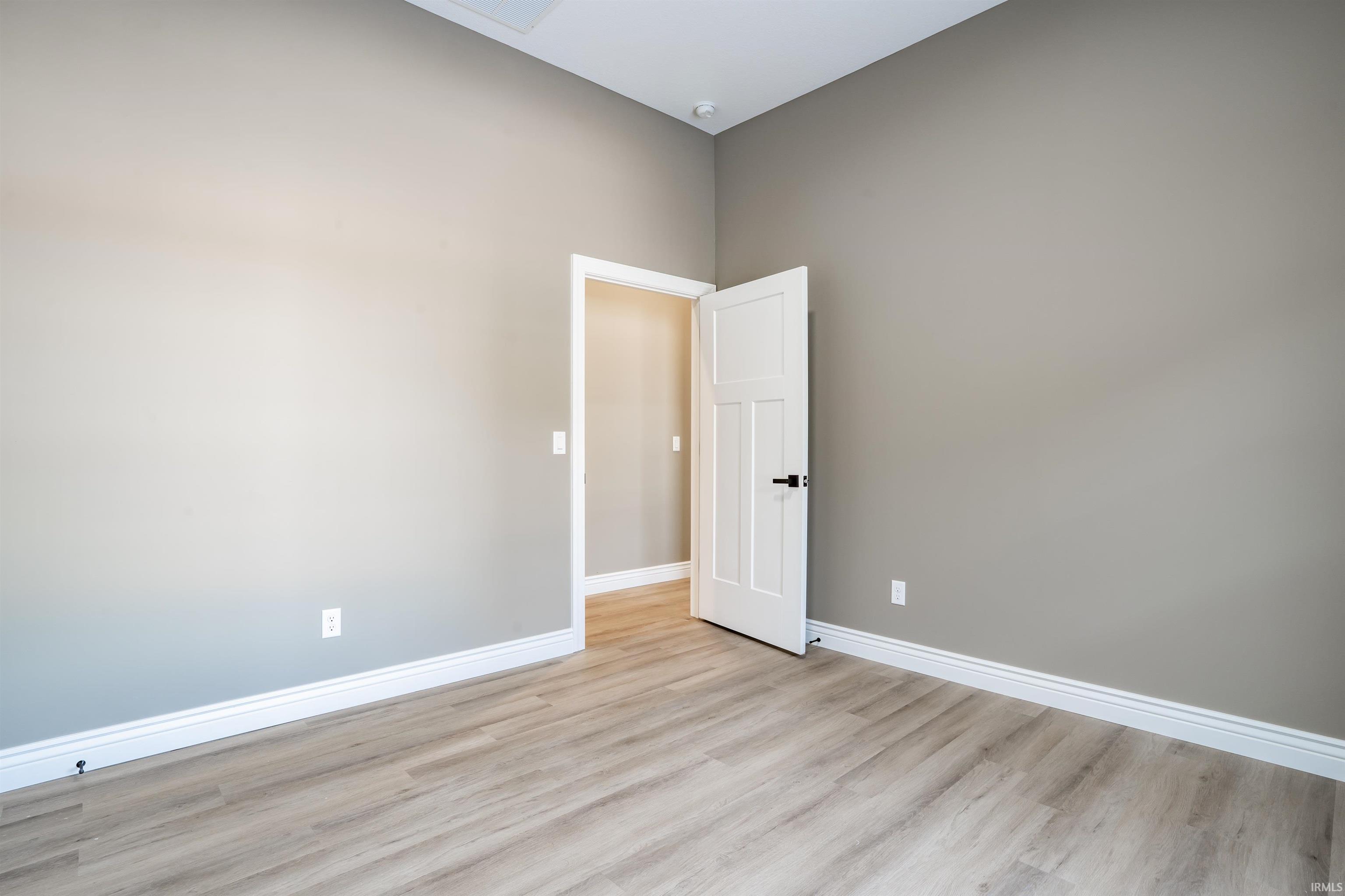 Spare room with baseboards and light wood finished floors