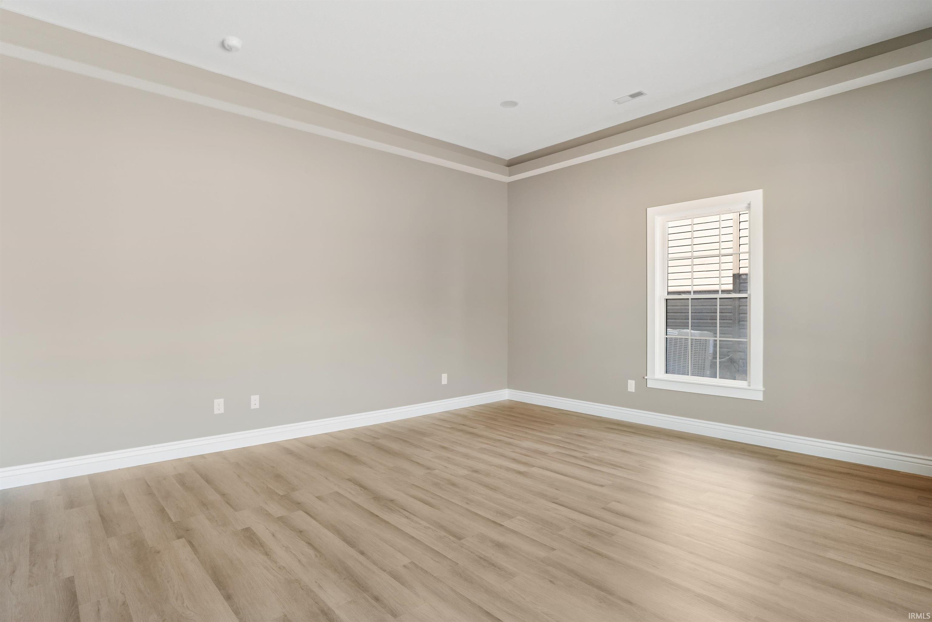 Unfurnished room featuring light wood finished floors and crown molding