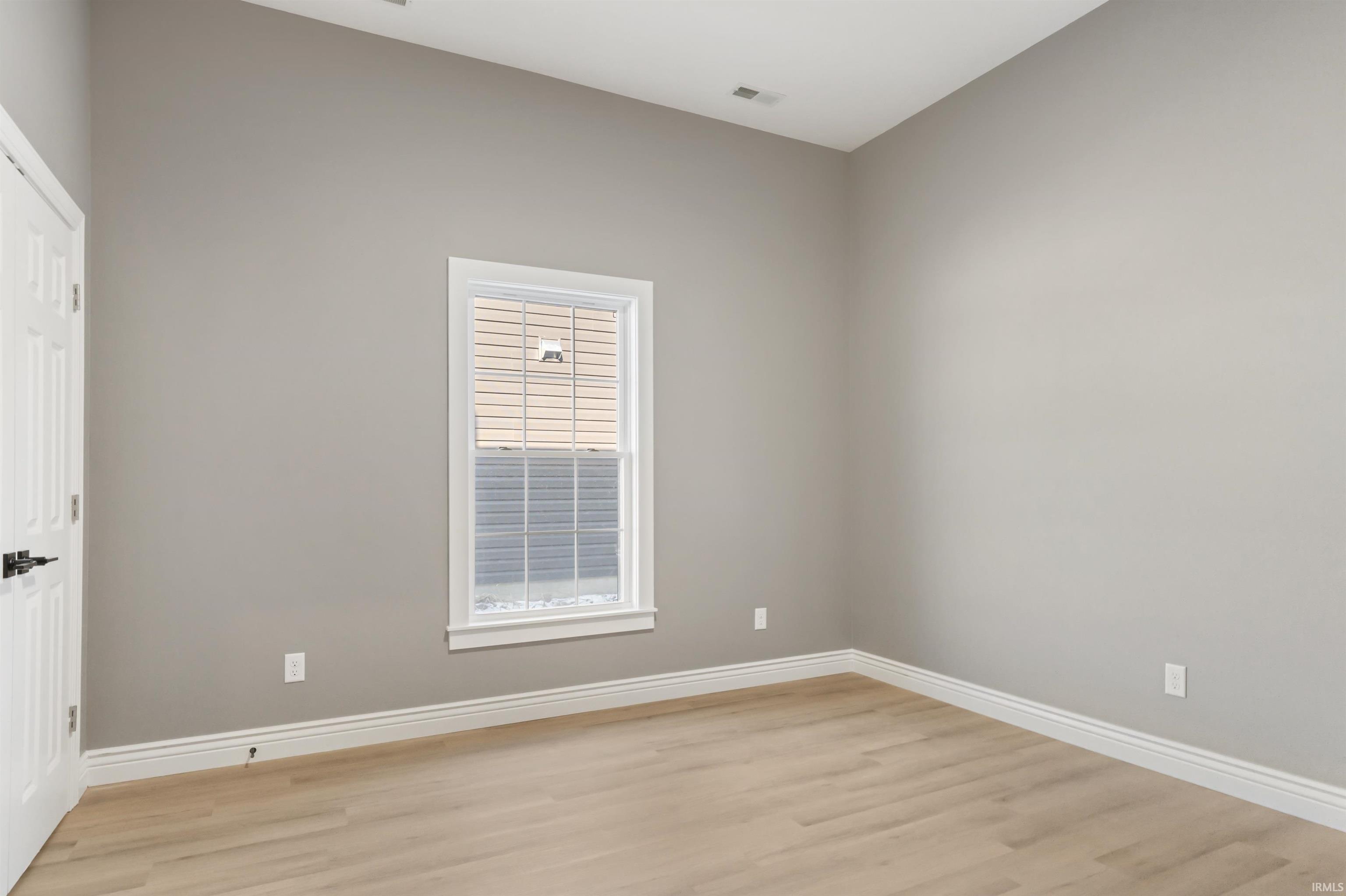 Unfurnished room with baseboards and light wood-style flooring