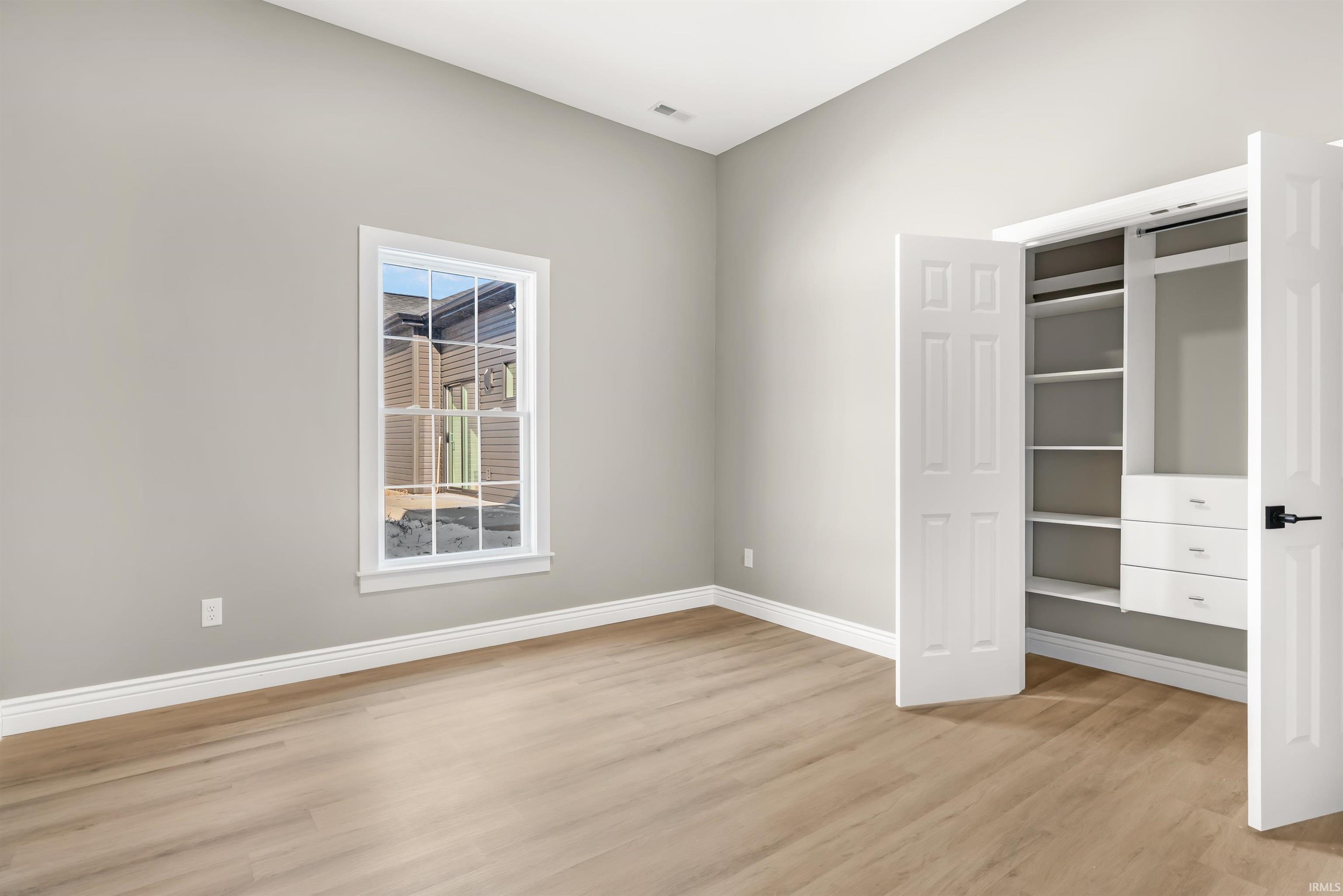 Unfurnished bedroom with light wood-style floors and a closet