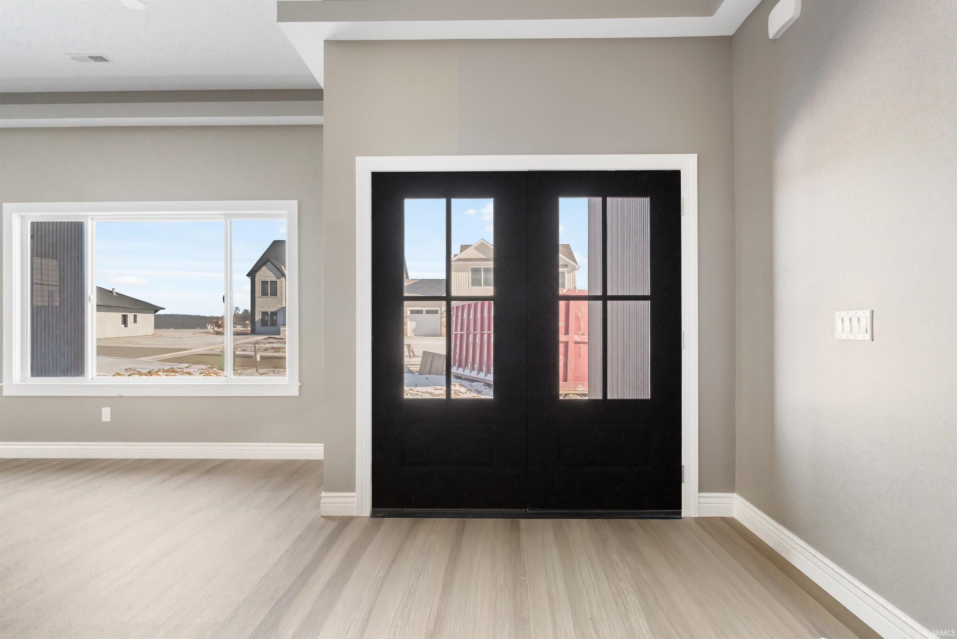 Foyer with light wood finished floors and french doors