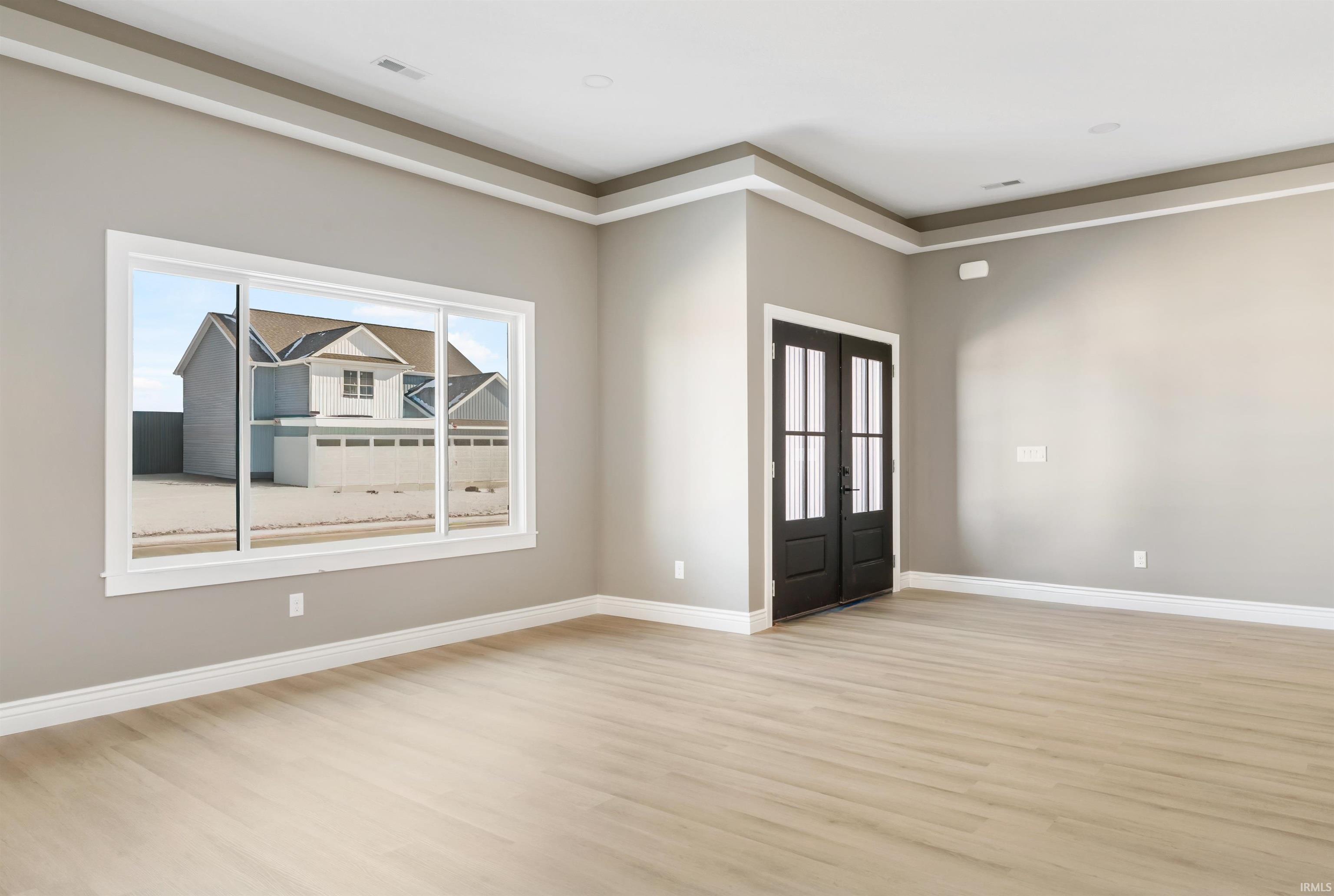 Spare room with french doors and light wood finished floors
