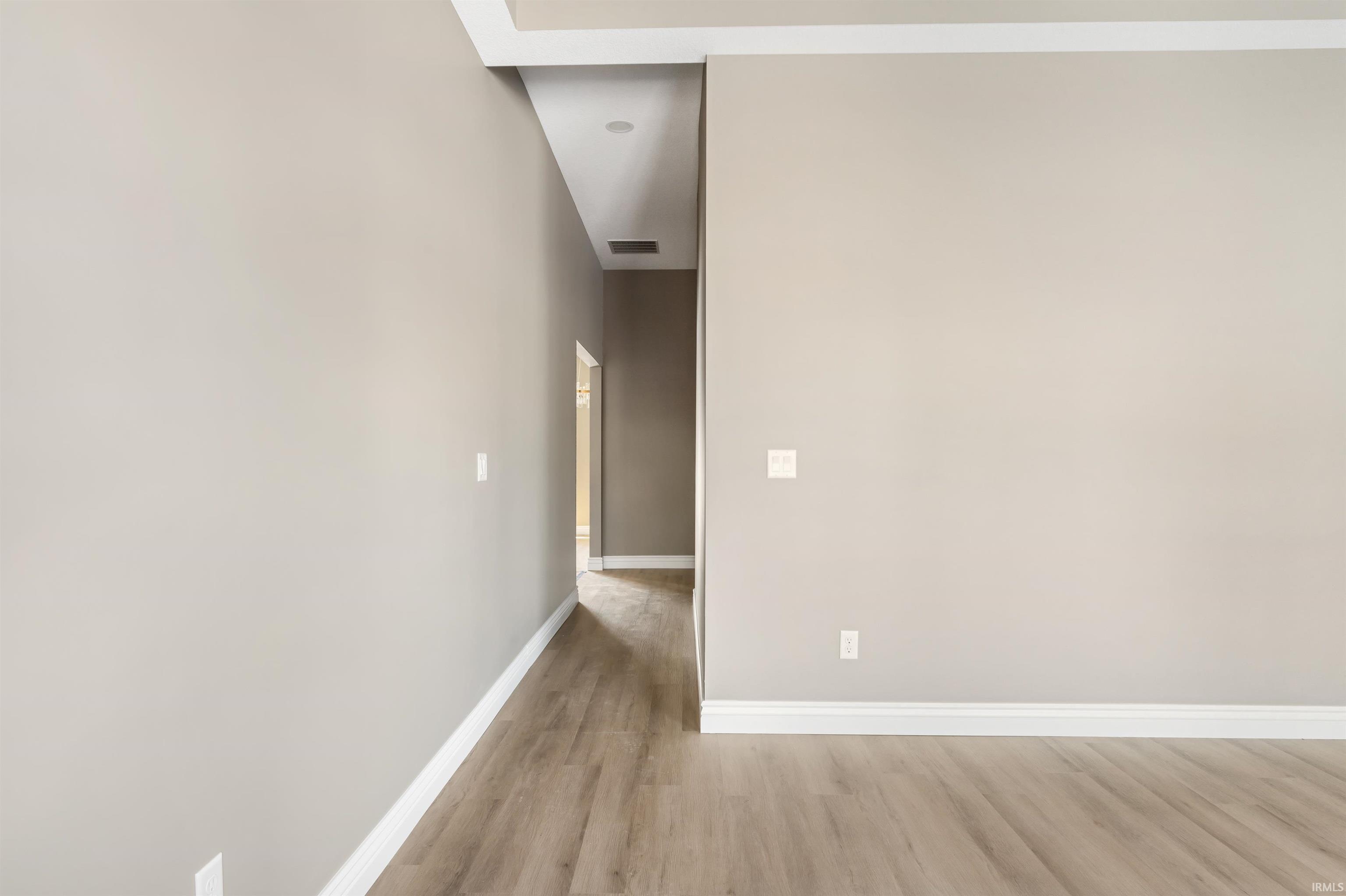 Corridor with light wood finished floors and baseboards