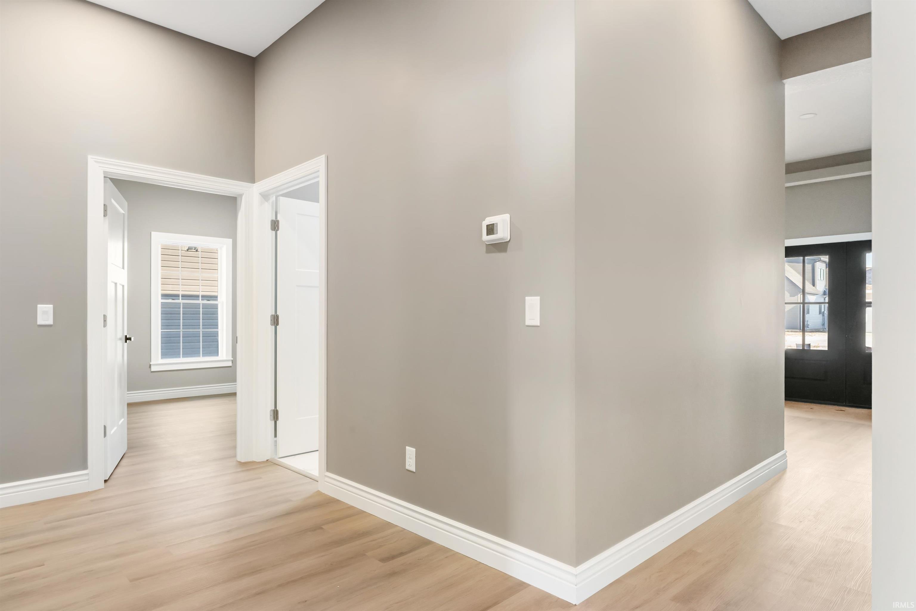 Hallway with light wood finished floors and french doors