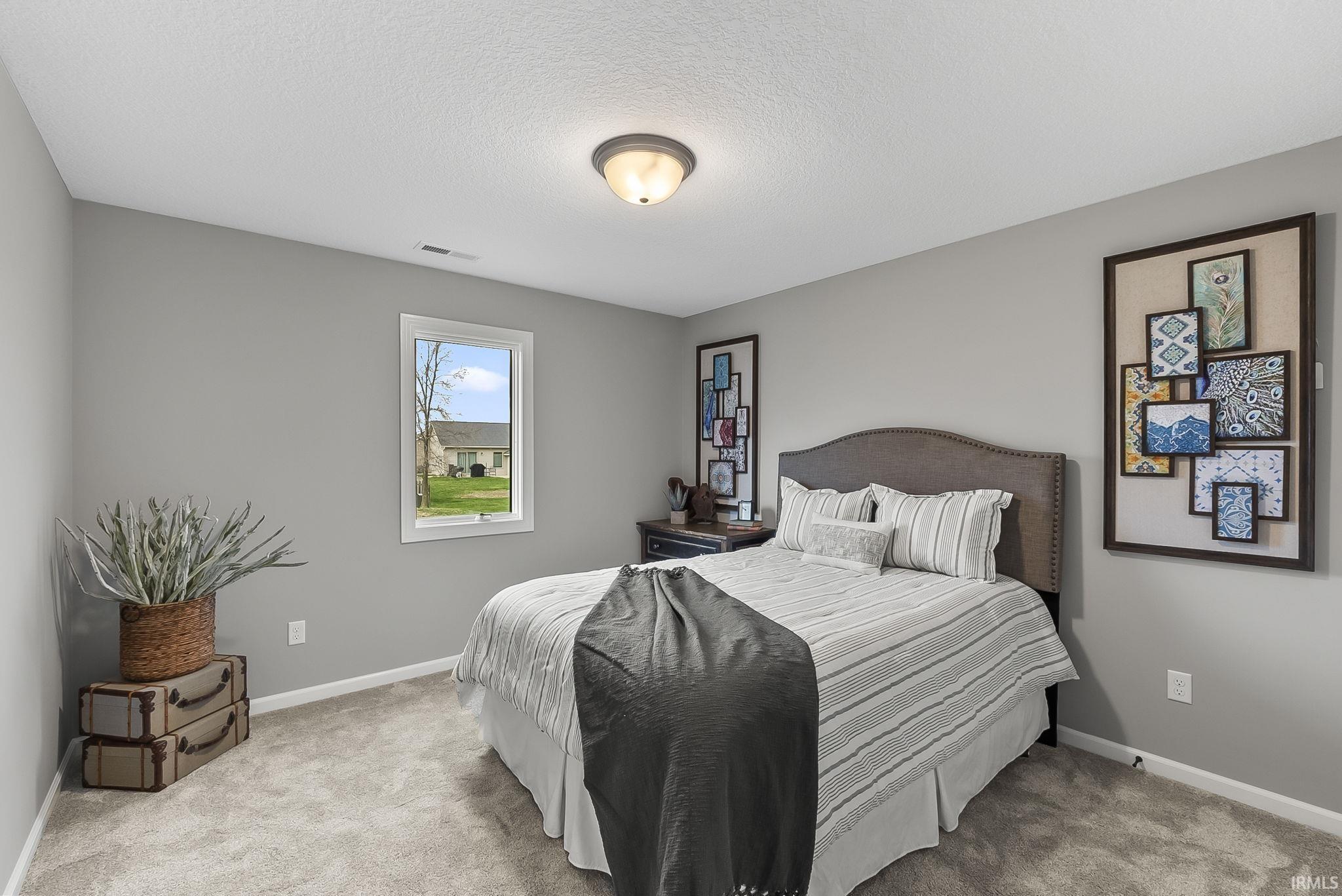 Bedroom featuring light carpet and a textured ceiling