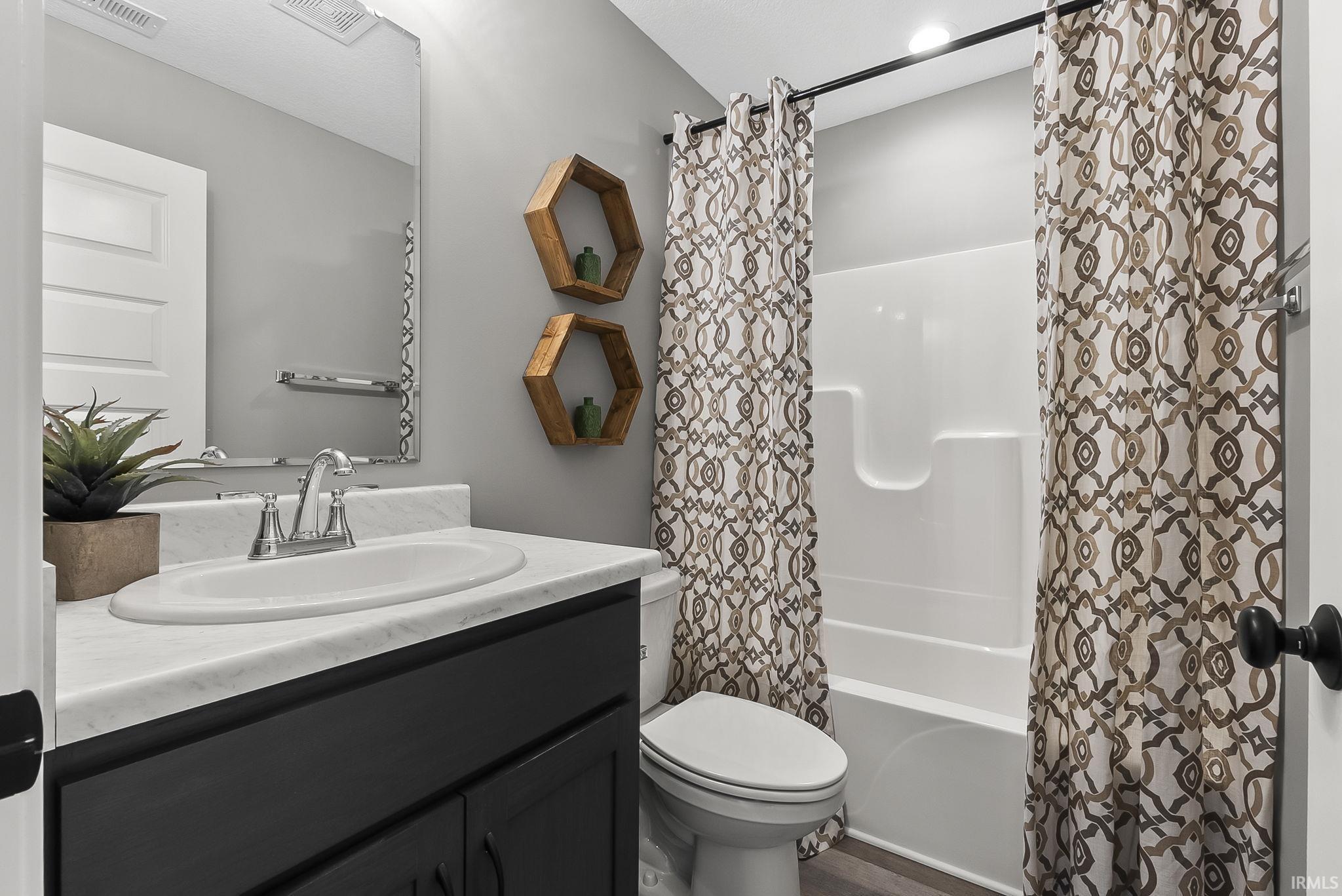 Full bath with vanity and shower / bath combo with shower curtain