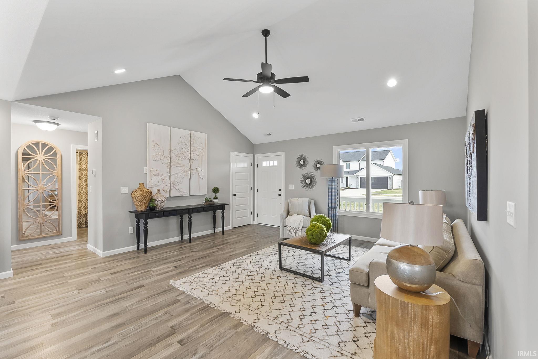 Living room with ceiling fan, recessed lighting, light wood-type flooring, and a high ceiling