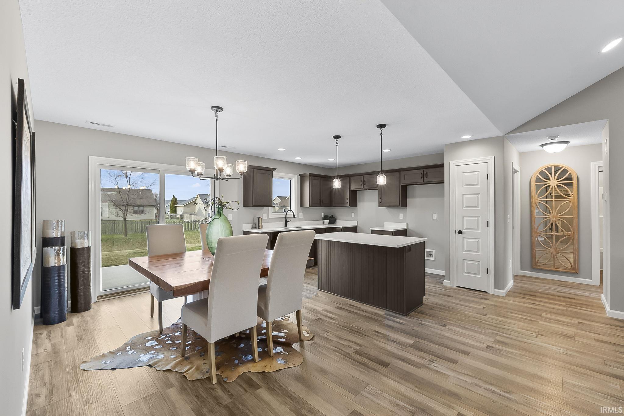 Dining area with suspended lighting and light wood-style floors