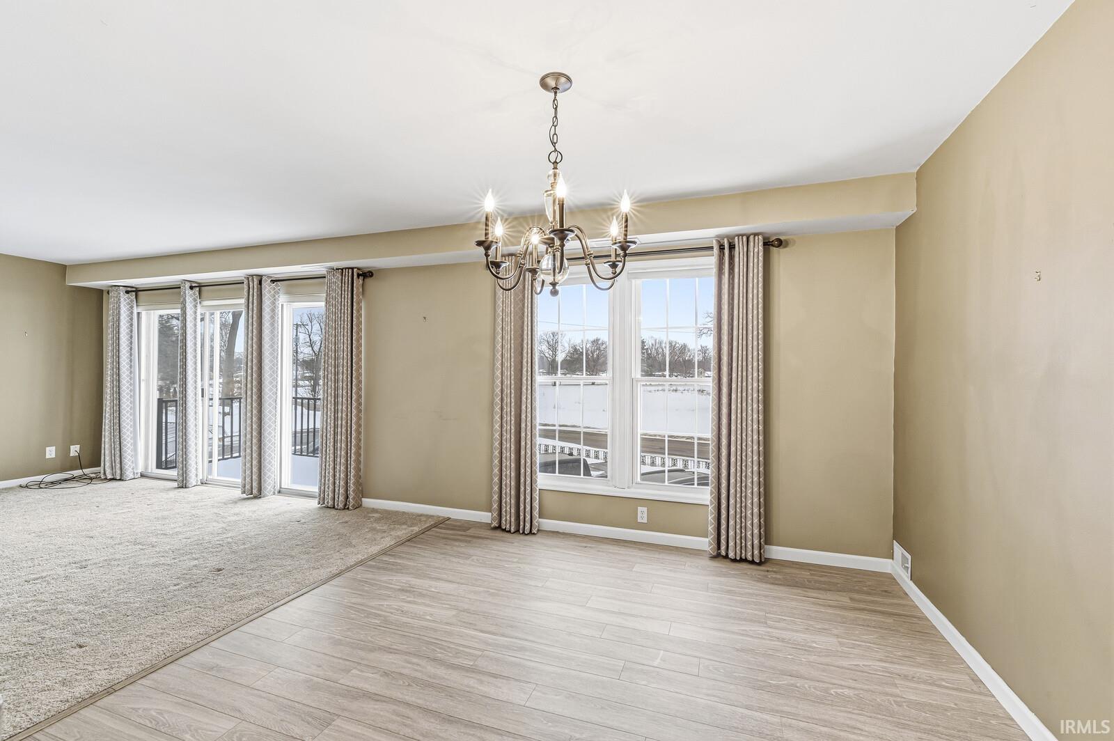Spare room featuring a chandelier and light wood finished floors