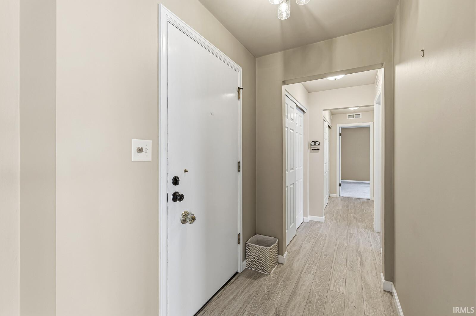 Hallway featuring light wood finished floors and baseboards