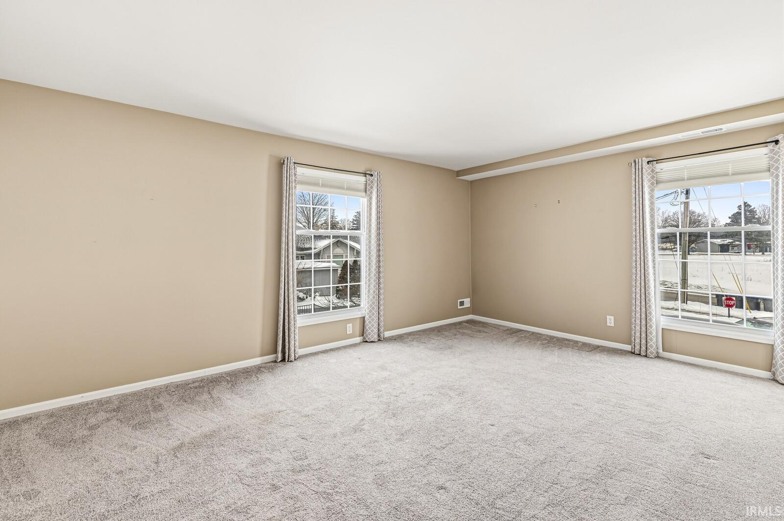 Spare room with light colored carpet and baseboards