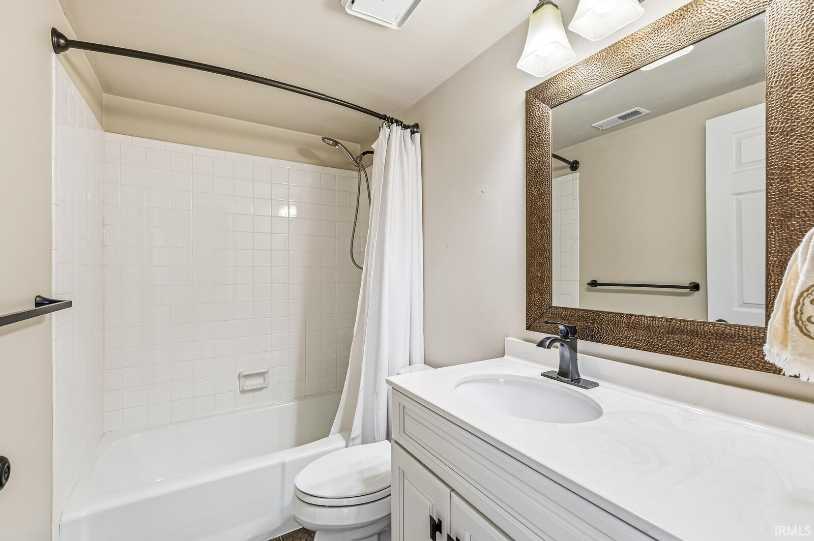 Bathroom with vanity and shower / tub combo with curtain