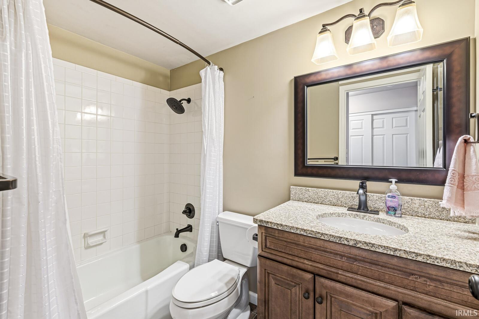 Full bath featuring shower / bath combination with curtain and vanity