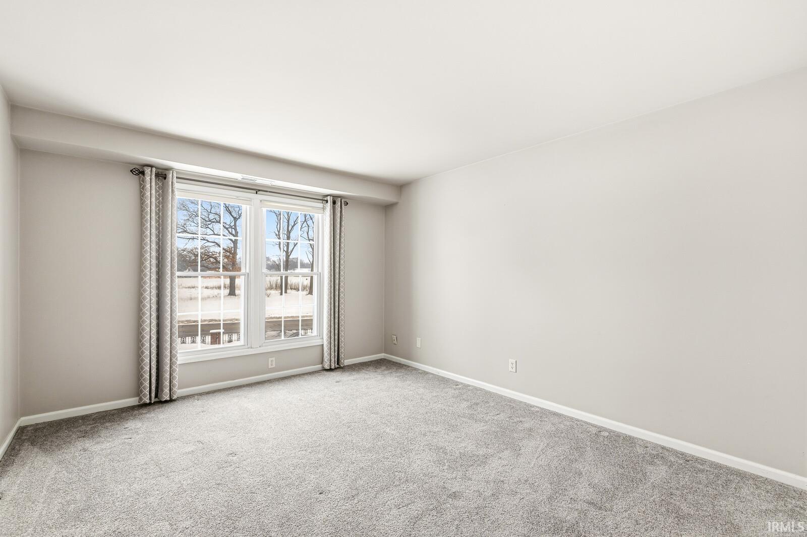 Carpeted spare room with baseboards