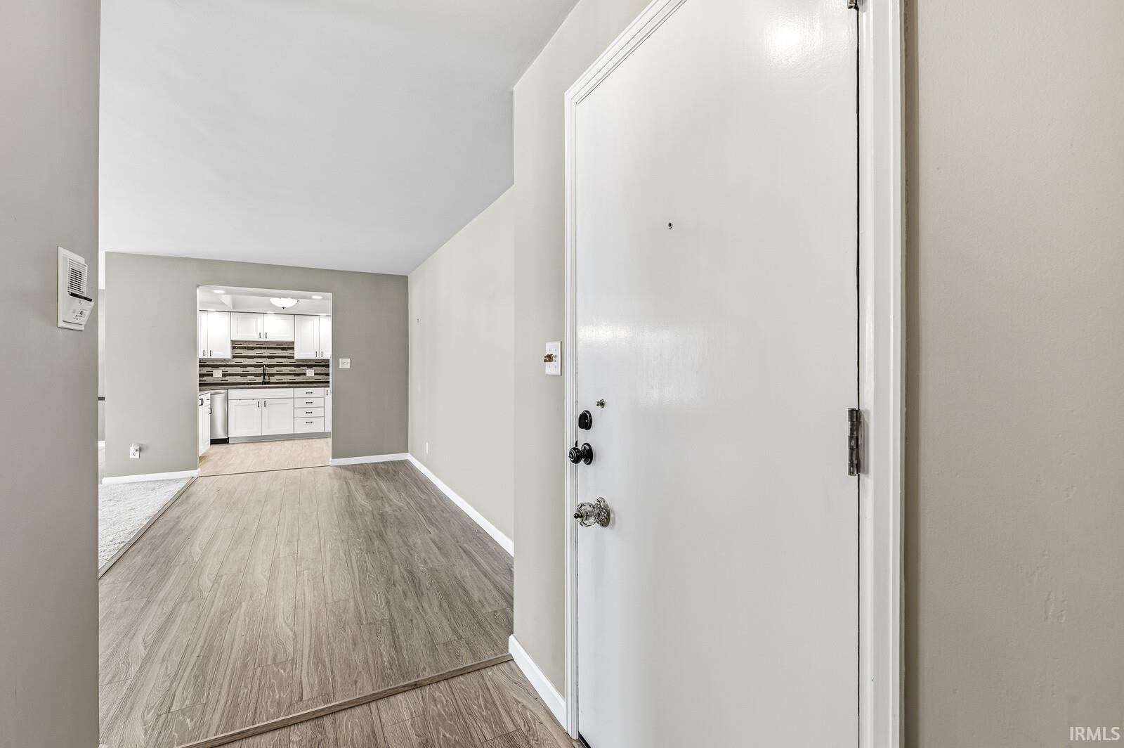 Foyer entrance with light wood-type flooring and baseboards