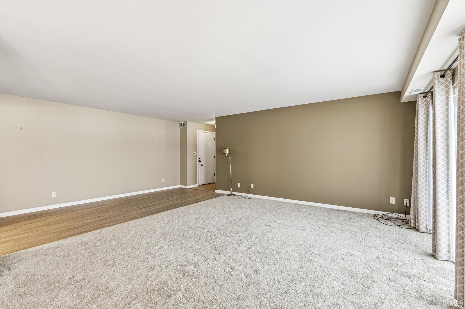 Empty room featuring baseboards and carpet