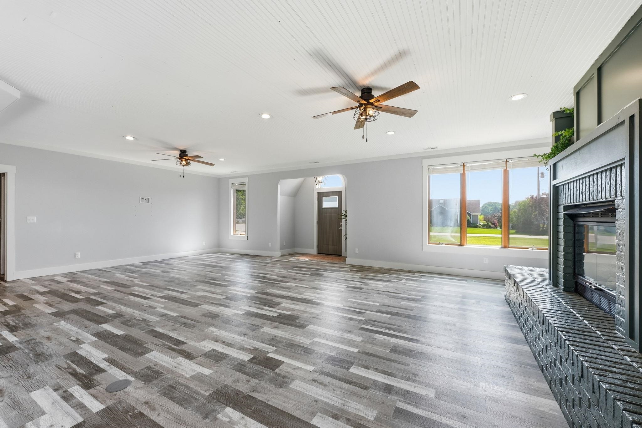 Spacious living area featuring wood-finish flooring, a beadboard ceiling, recessed lighting, and multiple ceiling fans